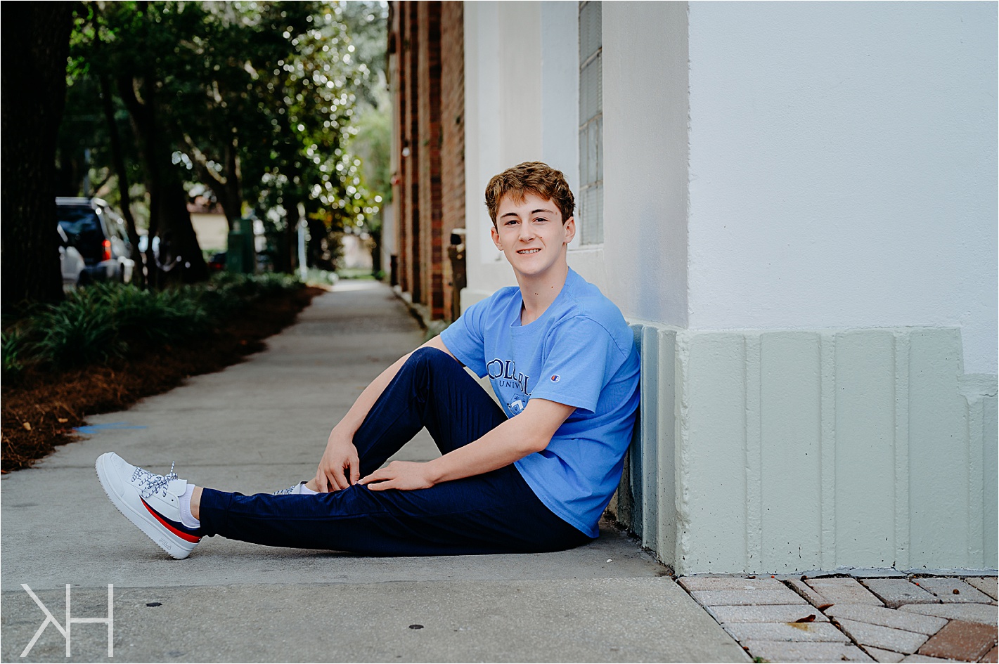 Senior guy against a wall in a blue shirt