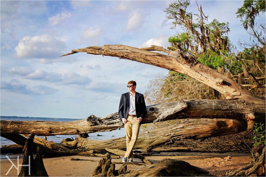 Senior guy photos on a fallen tree in Jacksonville, Florida